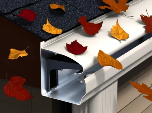 Image of a gutter system with a close-up view of its profile, surrounded by colorful autumn leaves, highlighting the importance of gutter maintenance during fall to prevent clogs and water damage.